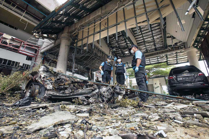 Ahli forensik melakukan penyelidikan untuk mencari barang bukti di lokasi ledakan bom di luar sebuah hotel di Provinsi Pattani, Senin.
