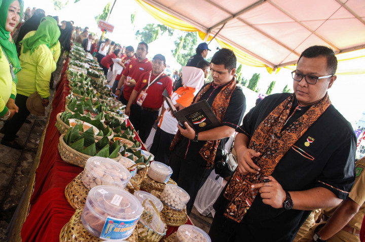 Senior Manager MURI Awan Rahargo (kanan) memberi penilaian saat melihat makanan berbahan dasar sagu yang dipamerkan di halaman Kantor Gubernur Riau, Pekanbaru, Riau, Selasa (25/10/2016)