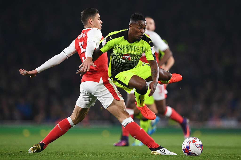 Pemain belakang Arsenal Gabriel mencoba menghadang laju gelandang Reading Callum Harriott.