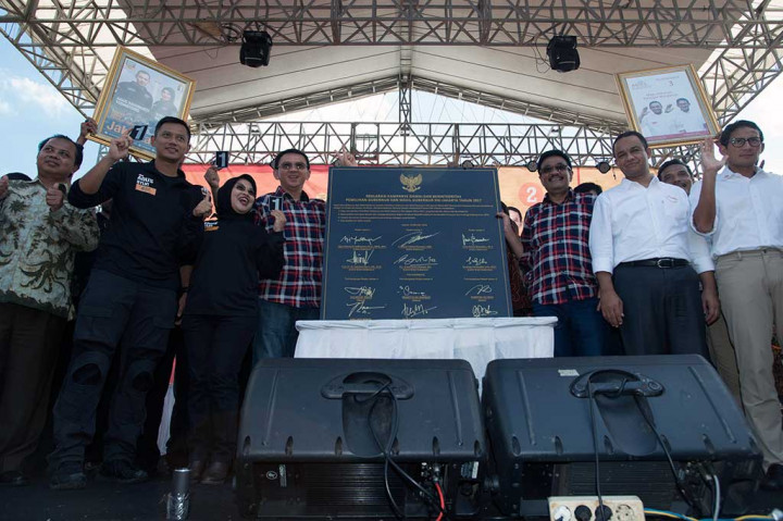 Ketua KPU DKI Jakarta Sumarno (kiri) bersama tiga pasangan cagub/cawagub DKI Jakarta berfoto bersama seusai menandatangani piagam kampanye Deklarasi Kampanye Damai dan Berintegritas.