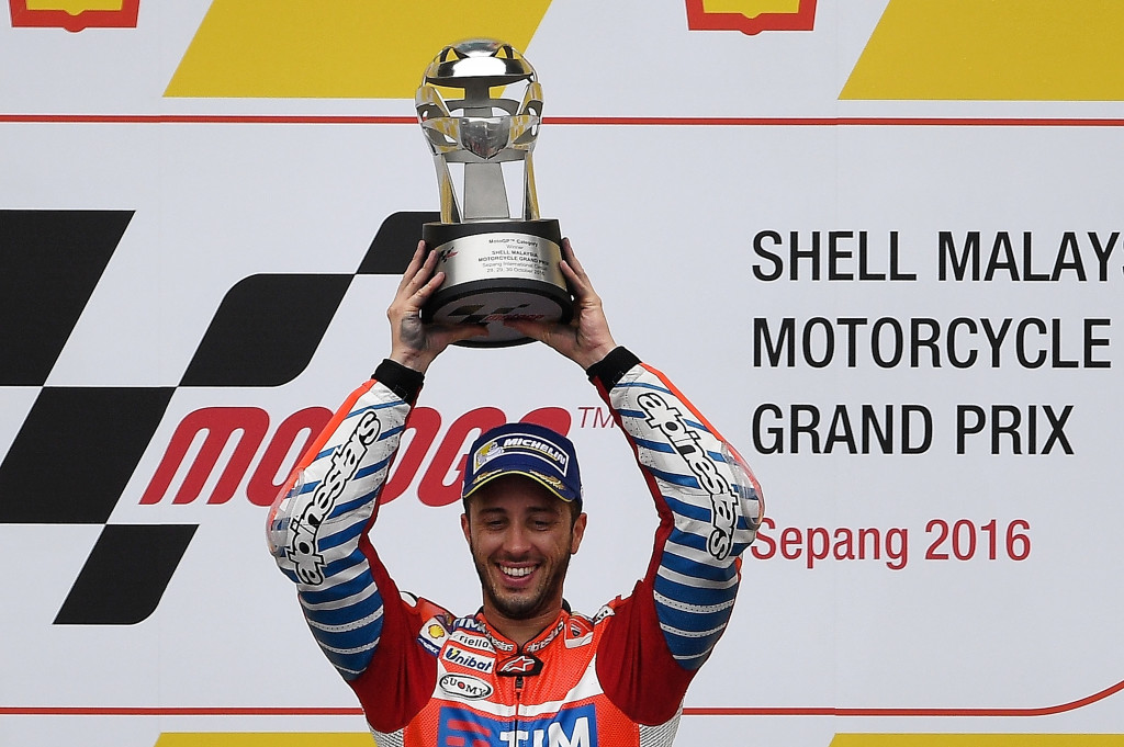 Pembalap Ducati, Andrea Dovizioso mengangkat trofi yang diraihnya usai memenangi balapan GP Malaysia