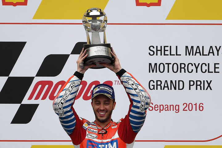 Pembalap Ducati, Andrea Dovizioso mengangkat trofi yang diraihnya usai memenangi balapan GP Malaysia