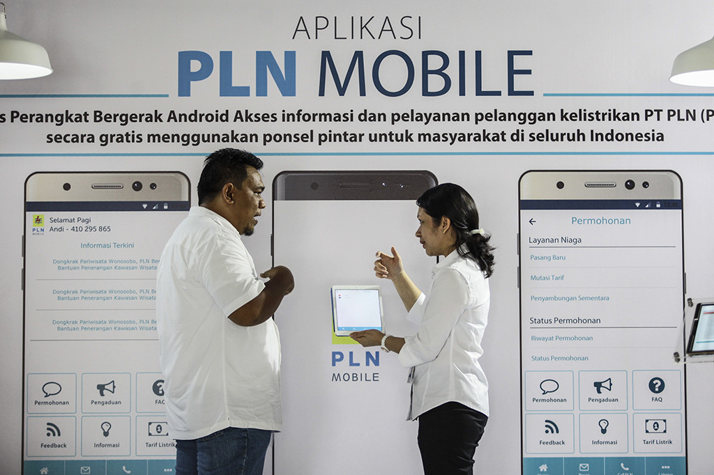 Petugas menunjukkan cara penggunaan aplikasi PLN Mobile kepada pengunjung saat peluncuran Aplikasi PLN Mobile di kantor PLN Pusat, Jakarta, Senin (31/10/2016)