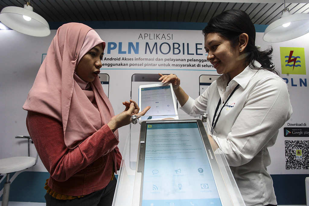 Petugas menunjukkan cara penggunaan aplikasi PLN Mobile kepada pengunjung saat peluncuran Aplikasi PLN Mobile di kantor PLN Pusat, Jakarta, Senin (31/10/2016)