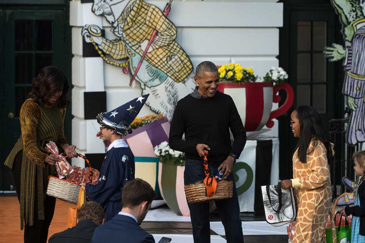 Presiden AS Barack Obama dan istrinya Michelle Obama memberikan bingkisan kepada anak-anak yang menghadiri perayaan Halloween di Gedung Putih, Washington.