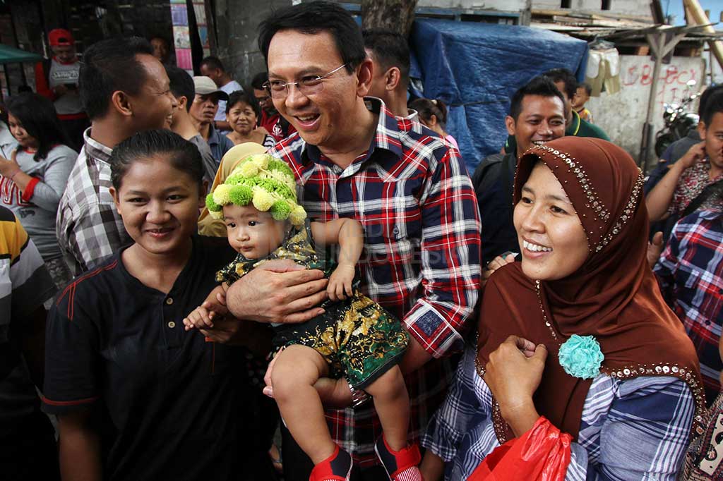 Ahok berfoto dengan warga saat blusukan di kawasan Serdang, Kemayoran, Jakarta.