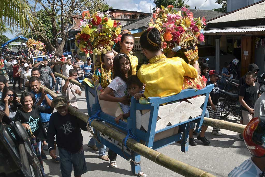 Warga mengarak anak gadis berkeliling kampung menggunakan kasonda'a atau tandu pada tradisi adat Karia'a di Pulau Wanci, Wakatobi, Senin (1/11/2016).