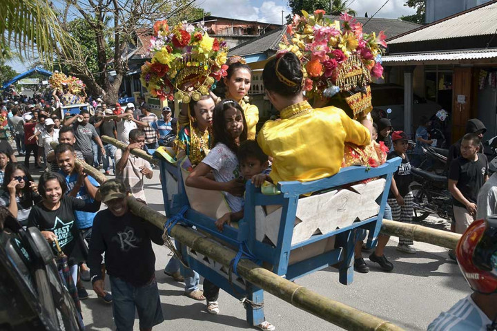 Warga mengarak anak gadis berkeliling kampung menggunakan kasonda'a atau tandu pada tradisi adat Karia'a di Pulau Wanci, Wakatobi, Senin (1/11/2016).