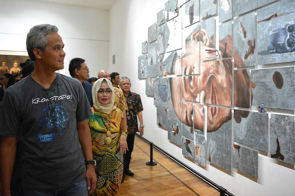 Gubernur Jateng Ganjar Pranowo mengamati karya seni rupa berjudul 'Man of The Year #4' usai membuka pameran Biennale Jateng bertema 'Kronotopos' di Semarang Contemporary Art Gallery, Semarang, Jawa Tengah, Selasa (1/11/2016).