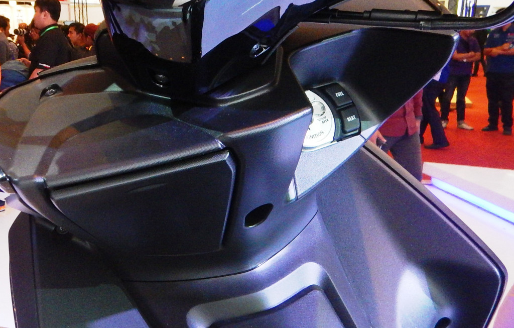 Berbeda dengan Aerox 125, di Aerox 155 ada laci kecil dengan penutup yang sama seperti Honda PCX 150. Di samping lubang kunci kontak terdapat tombol pembuka jok dan tanki bahan bakar.  