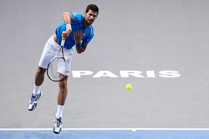 Sang juara bertahan Novak Djokovic melancarkan servis ke arah Gilles Muller.