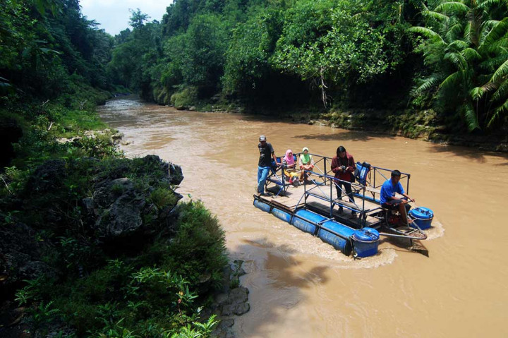 Wisatawan menikmati keindahan alam dengan menumpang perahu motor saat menyusuri Sungai Oya.