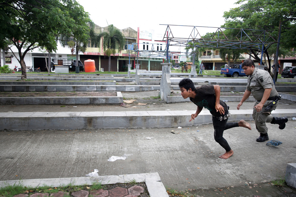 Petugas Satpol PP dan Wilayatul Hisbah mengejar anak punk yang berupaya melarikan diri saat razia penyakit masyarakat (pekat) di Terminal Keudah, Banda Aceh, Aceh, Kamis (3/11/2016)