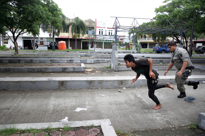 Petugas Satpol PP dan Wilayatul Hisbah mengejar anak punk yang berupaya melarikan diri saat razia penyakit masyarakat (pekat) di Terminal Keudah, Banda Aceh, Aceh, Kamis (3/11/2016)
