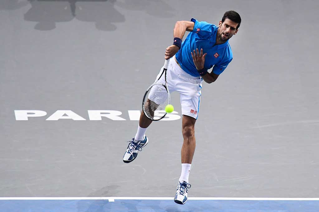 Novak Djokovic melancarkan servis ke arah Grigor Dimitrov.