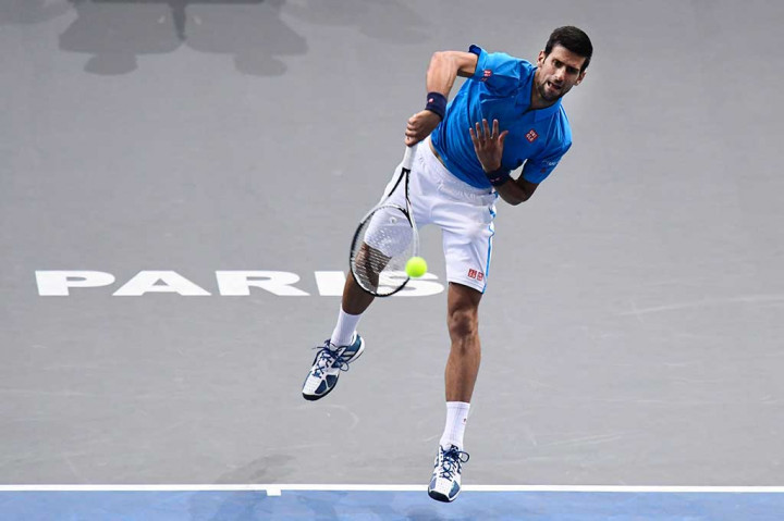 Novak Djokovic melancarkan servis ke arah Grigor Dimitrov.