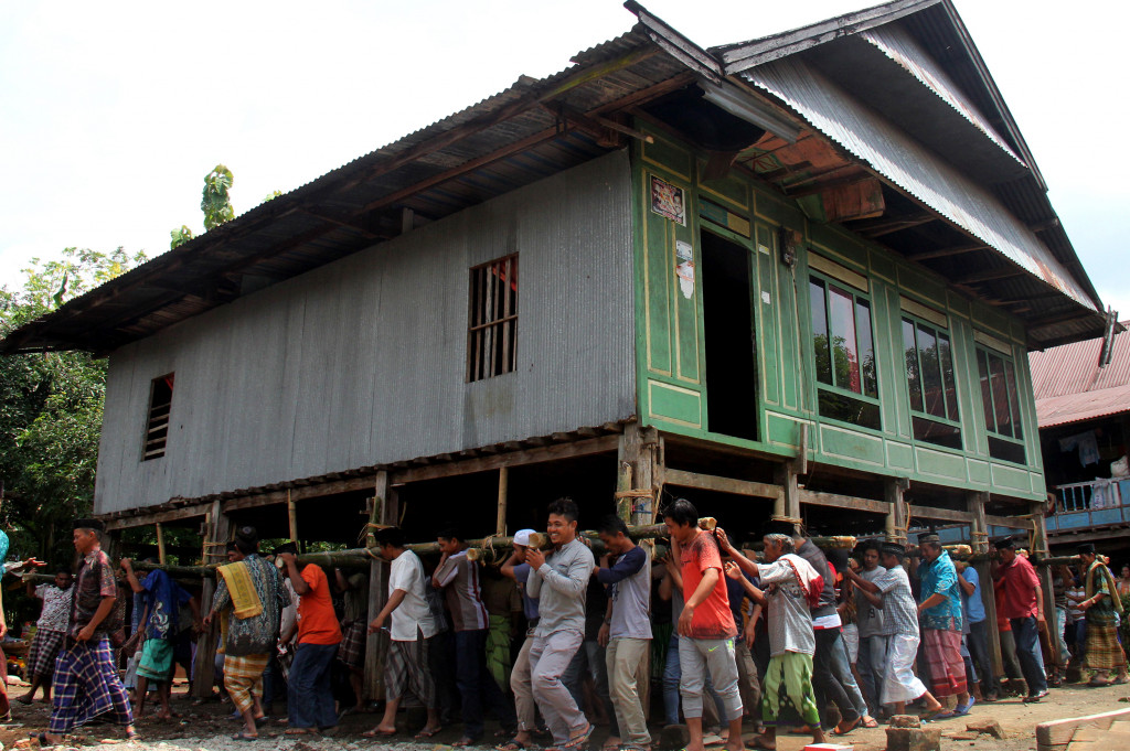 Sejumlah warga bergotong royong memindahkan rumah panggung di Desa Barugaya, Kabupaten Takalar, Sulawesi Selatan, Jumat (4/11/2016)