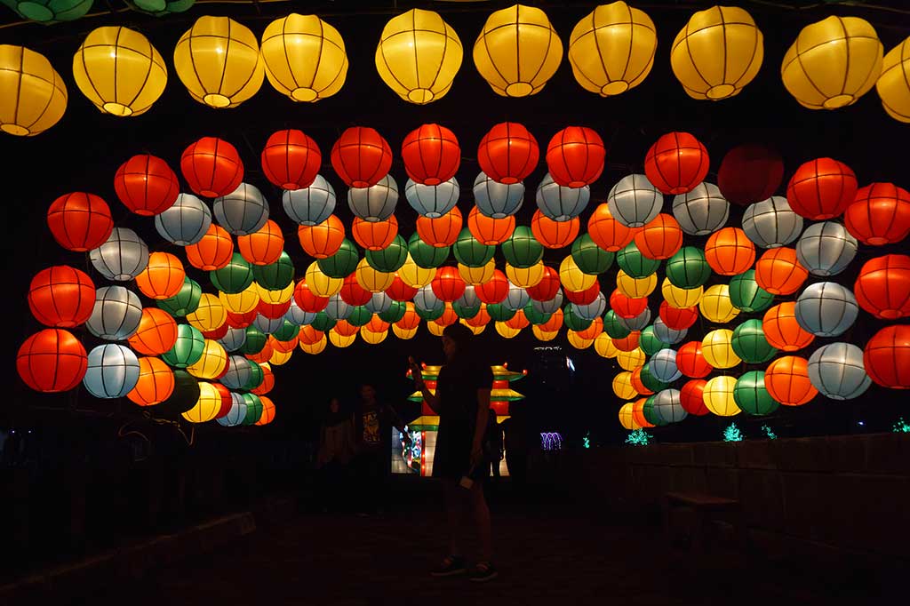 Pengunjung berfoto dengan latar belakang lampion di kawasan wisata malam Taman Pelangi, Sleman, DI Yogyakarta, Jumat (4/11/2016).