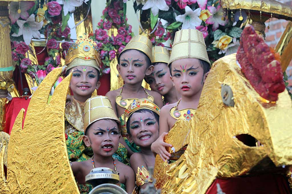 Sejumlah anak berada di atas kereta saat diarak keliling kampung bersama barong di Sobo, Banyuwangi.