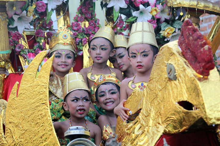 Sejumlah anak berada di atas kereta saat diarak keliling kampung bersama barong di Sobo, Banyuwangi.
