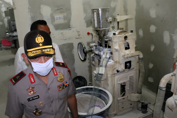Kapolda Banten Brigjen Pol Listyo Sigit Prabowo melintas di samping mesin pencetak pil saat penggerebekan pabrik obat ilegal di Jalan Sudirman, Serang, Banten, Senin (7/11/2016)