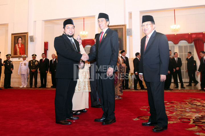 Presiden Joko Widodo (tengah) diikuti Wakil Presiden Jusuf Kalla mengucapkan selamat kepada cucu tokoh Nahdlatul Ulama (NU) almarhum Kiai Haji Raden (KHR) As'ad Syamsul Arifin, KHR. Ahmad Azaim Ibrahimy, atas gelar Pahlawan Nasional yang diterima almarhum di Istana Negara, Rabu (9/11/2016)