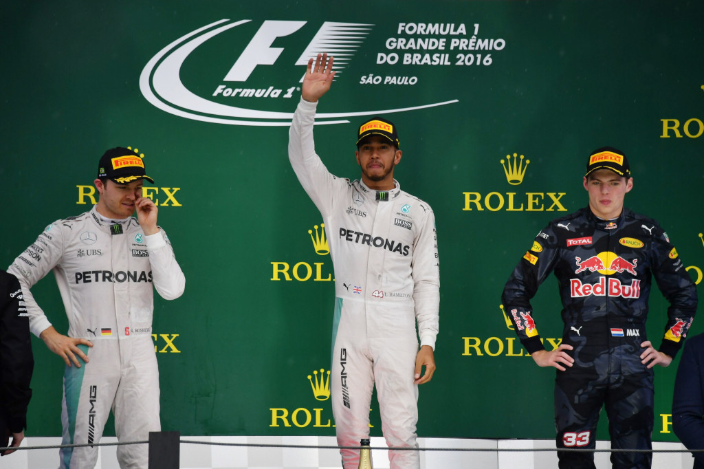 Hamilton (tengah) berhasil mengungguli rekan satu timnya Rosberg (kiri) yang harus puas menempati posisi kedua, disusul Verstappen di posisi ketiga