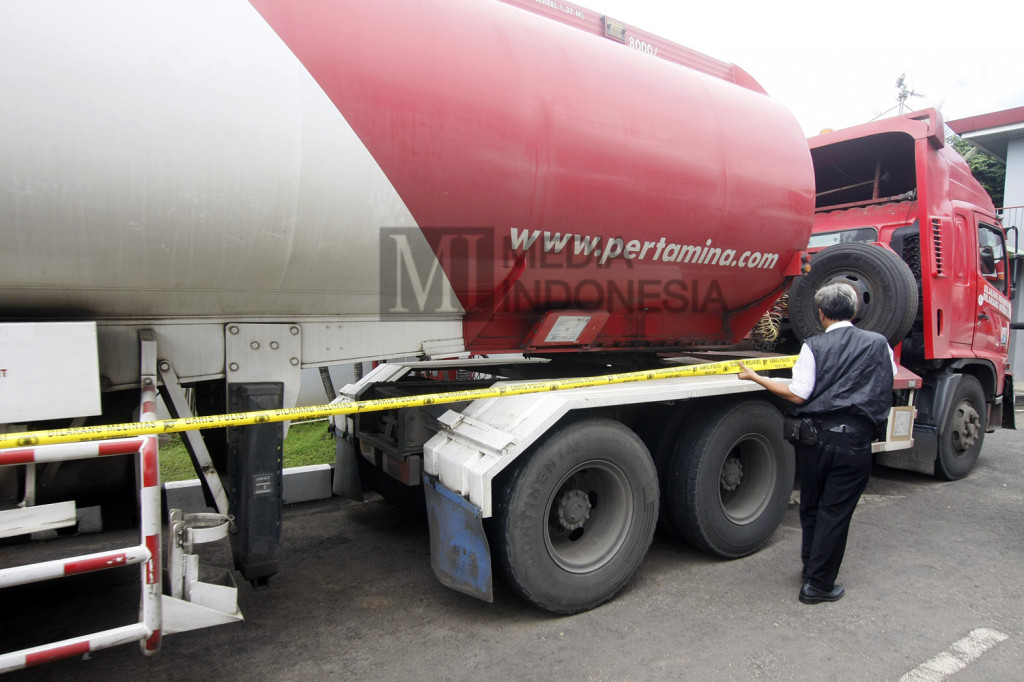 Penyidik dari Satreskrim Polresta Depok memasang garis polisi di truk pengisian bahan bakar solar di SPBU Juanda, Depok, Jawa Barat, Senin (14/11/2016)