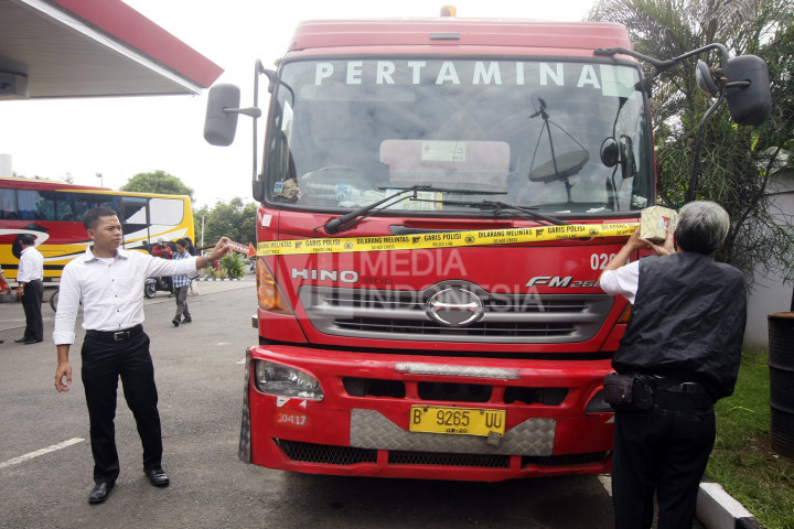 Penyidik dari Satreskrim Polresta Depok memasang garis polisi di truk pengisian bahan bakar solar di SPBU Juanda, Depok, Jawa Barat, Senin (14/11/2016)