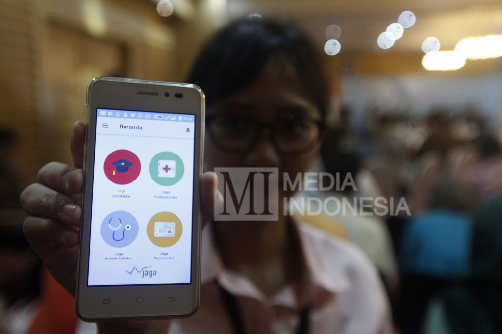 Seorang pengguna menunjukkan aplikasi mobile JAGA