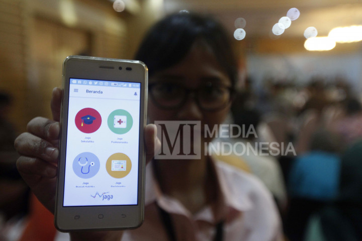 Seorang pengguna menunjukkan aplikasi mobile JAGA