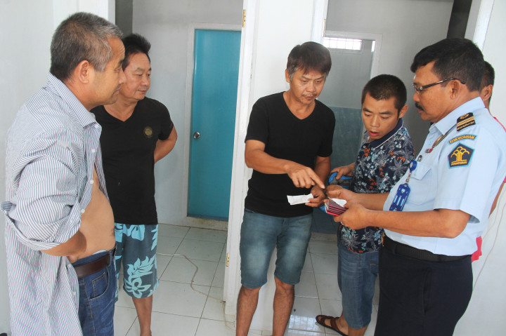Petugas imigrasi memeriksa paspor milik warga negara asing (WNA) di ruang detensi Kantor Imigrasi Kelas II B Meulaboh, Aceh Barat, Aceh, Selasa (15/11/2016).