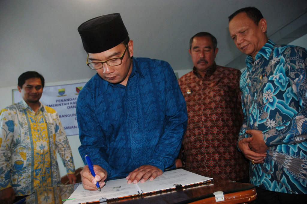 Wali Kota Bandung Ridwan Kamil (kedua kiri), Asisten Hukum dan HAM Provinsi Jawa Barat Achadiat (kanan), Bupati Bandung Barat Abubakar (kedua kanan), dan Wakil Bupati Kabupaten Bandung Gun Gun Gunawan (kiri) menandatangani nota kesepahaman antara Pemerintah Daerah se-Bandung Raya di Bandung, Jawa Barat, Kamis (17/11/2016)