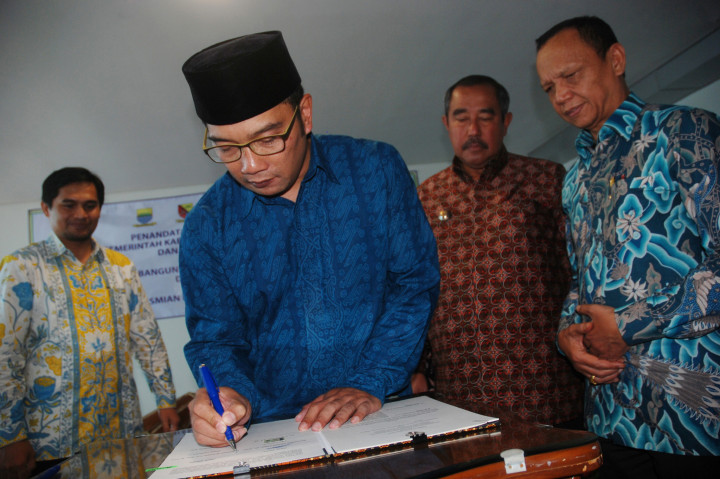 Wali Kota Bandung Ridwan Kamil (kedua kiri), Asisten Hukum dan HAM Provinsi Jawa Barat Achadiat (kanan), Bupati Bandung Barat Abubakar (kedua kanan), dan Wakil Bupati Kabupaten Bandung Gun Gun Gunawan (kiri) menandatangani nota kesepahaman antara Pemerintah Daerah se-Bandung Raya di Bandung, Jawa Barat, Kamis (17/11/2016)