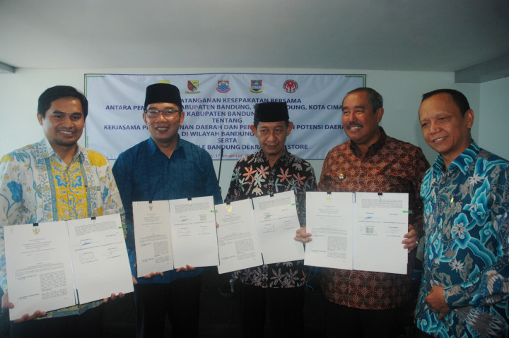 Wali Kota Bandung Ridwan Kamil (kedua kiri), Asisten Hukum dan HAM Provinsi Jawa Barat Achadiat (kanan), Bupati Bandung Barat Abubakar (kedua kanan), Wakil Wali Kota Cimahi Sudiarto (tengah), Wakil Bupati Kabupaten Bandung Gun Gun Gunawan (kiri) memperlihatkan nota kesepahaman antara Pemerintah Daerah se-Bandung Raya di Bandung, Jawa Barat, Kamis (17/11/2016)