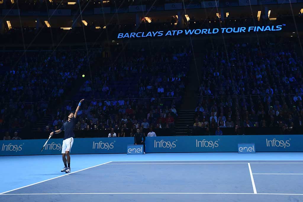 Novak Djokovic melancarkan servis ke arah petenis Belgia David Goffin pada laga Grup Ivan Lendl di O2 Arena, Kamis.