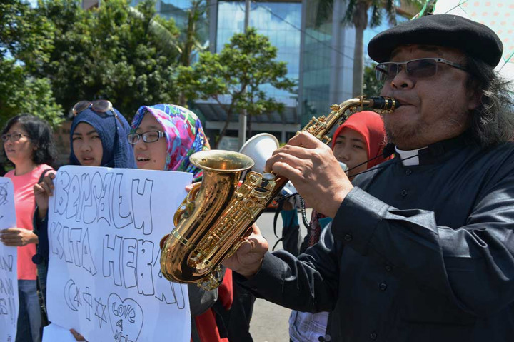 Romo Aloysius Budi Purnomo memainkan saksofon dalam aksi memperingati Hari Toleransi Internasional yang digelar oleh Jaringan Masyarakat Semarang untuk Keberagaman, di Semarang, Jawa Tengah.