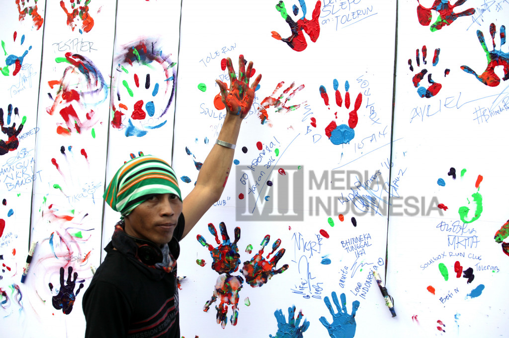 Peserta membubuhkan tanda telapak tangan dengan tinta pada spanduk dukungan saat berpartisipasi pada kegiatan lari untuk toleransi 'ToleRun' di kawasan Senayan, Jakarta, Minggu (20/11/2016)
