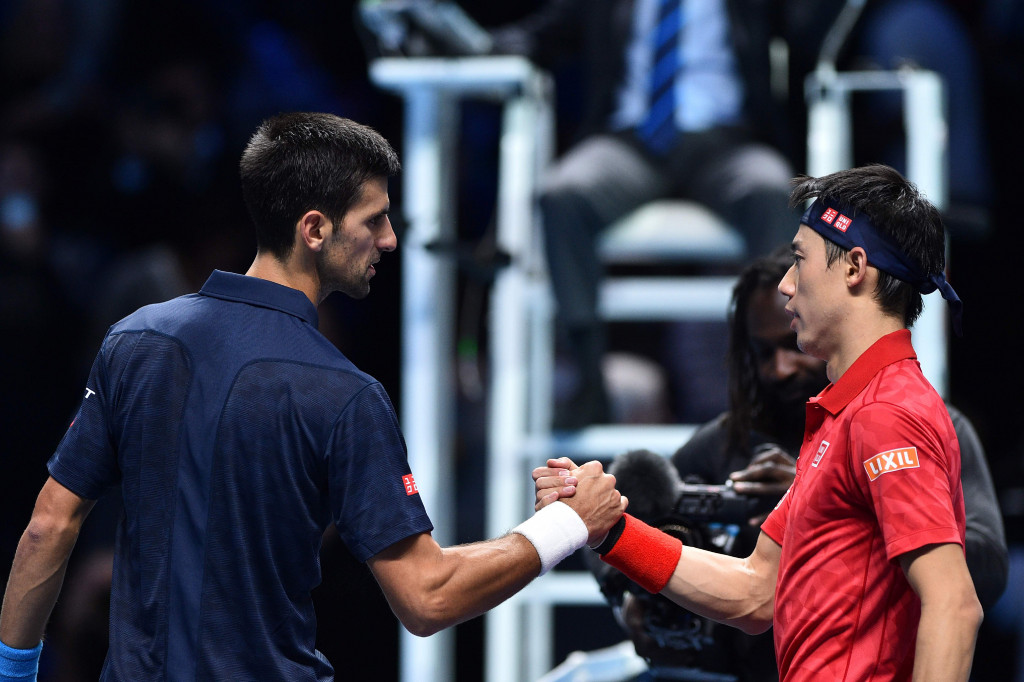 Novak Djokovic (kiri) berjabat tangan dengan Kei Nishikori usai pertandingan semifinal ATP World Tour Finals