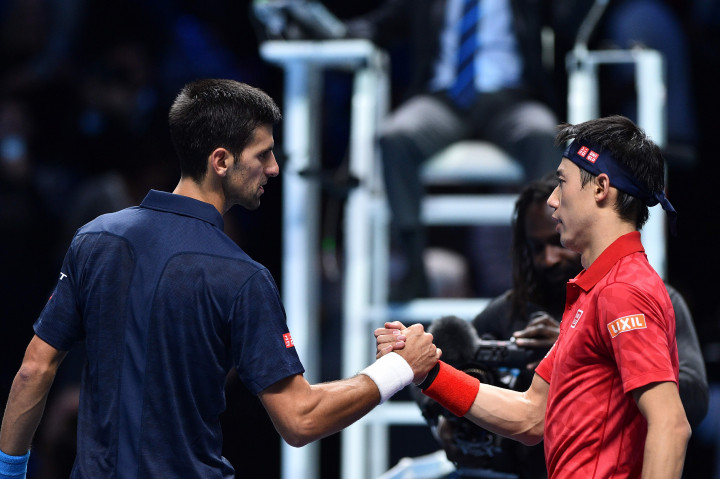 Novak Djokovic (kiri) berjabat tangan dengan Kei Nishikori usai pertandingan semifinal ATP World Tour Finals