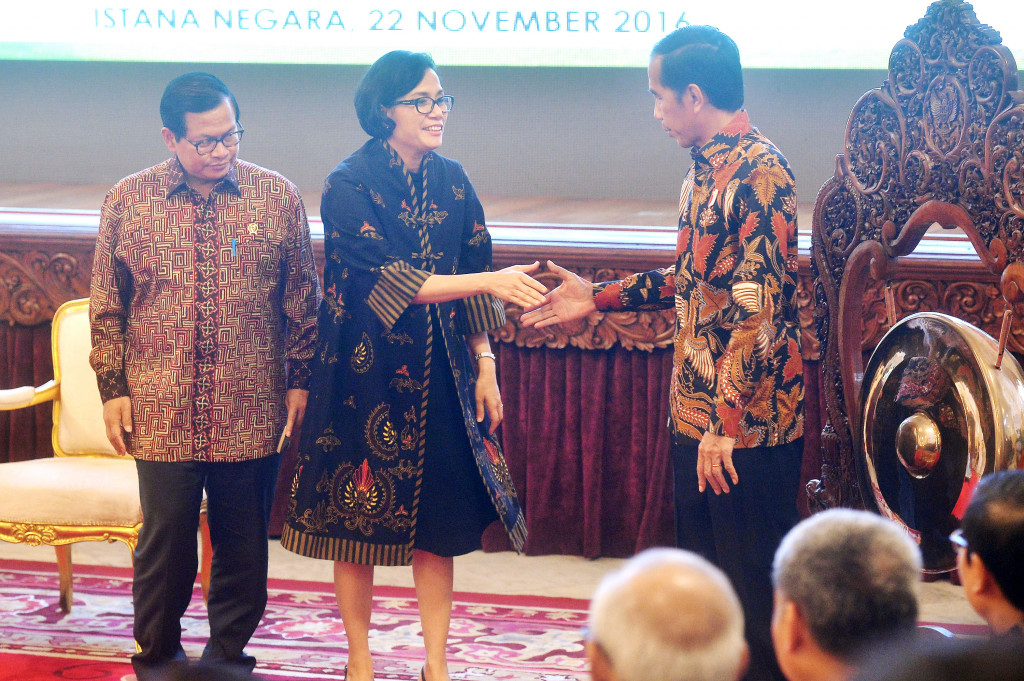 Presiden Joko Widodo (kanan) berjabat tangan dengan Menkeu Sri Mulyani Indrawati (tengah) disaksikan Seskab Pramono Anung saat pembukaan Rakornas Badan Layanan Umum (BLU) di Istana Negara, Jakarta, Selasa (22/11/2016)