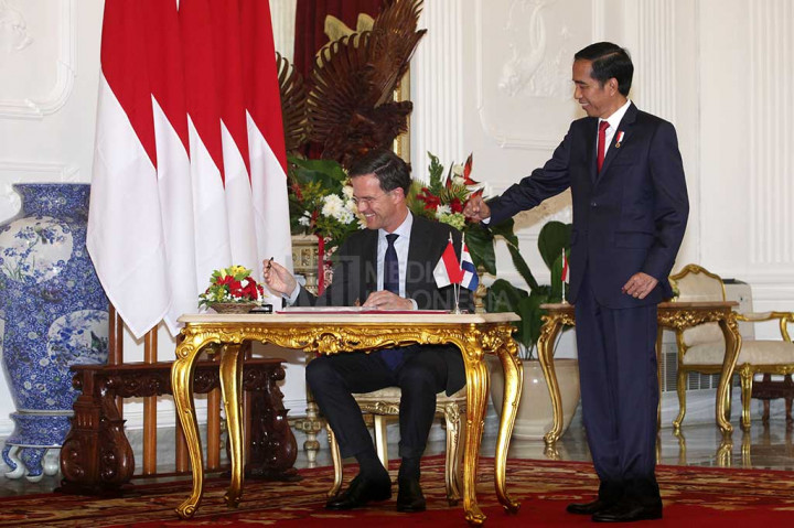 Presiden Jokowi mendampingi PM Kerajaan Belanda Mark Rutte mengisi buku tamu.