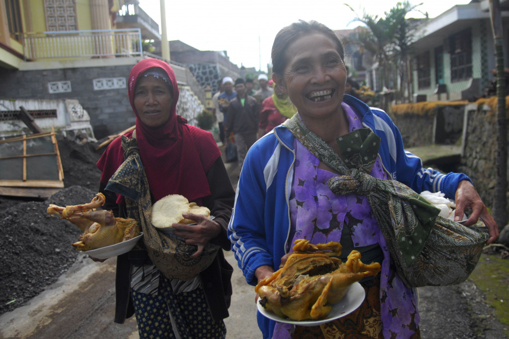 Warga membawa ingkung ayam dan nasi tumpeng.