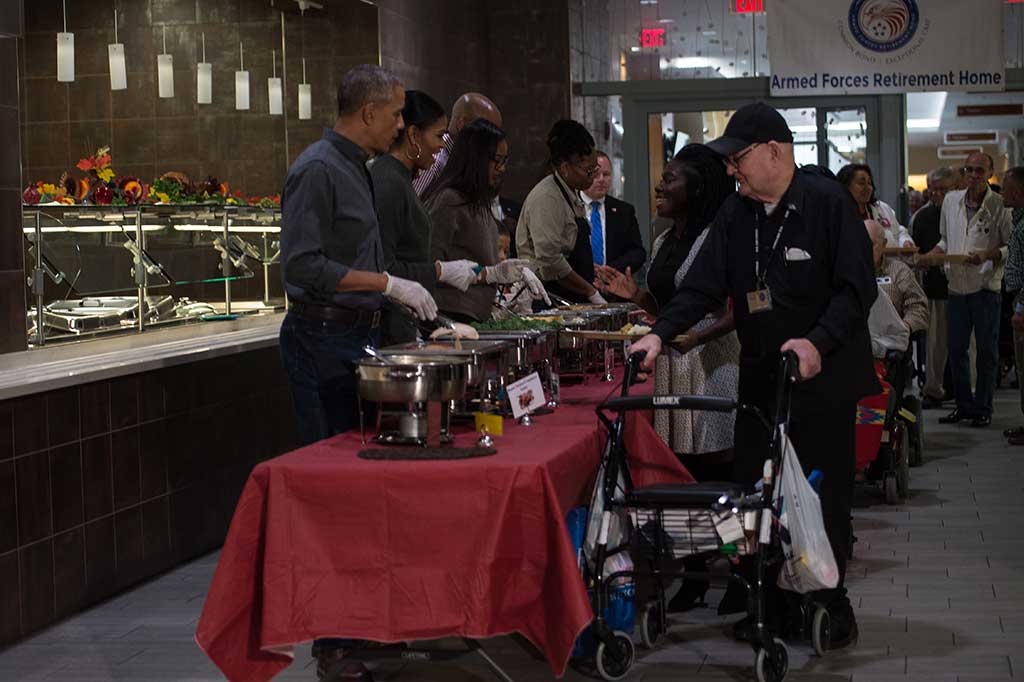 Presiden AS Barack Obama ditemani istri Michelle Obama dan putrinya Sasha melayani dan membagikan makan siang kepada para veteran Perang Dunia I.