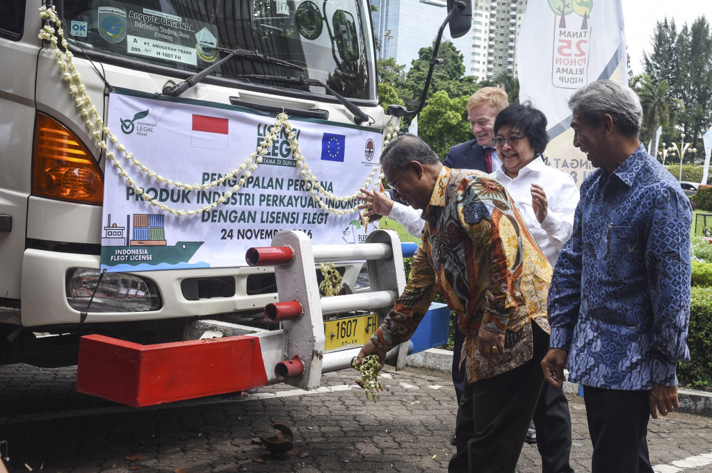 Menko Perekonomian Darmin Nasution (kiri) memecahkan kendi di truk pengangkut peti kemas berisi produk kayu Indonesia disaksikan Menteri Lingkungan Hidup dan Kehutanan Siti Nurbaya (kedua kanan), Wakil Menteri Luar Negeri A.M. Fachir (kanan) dan Dubes Uni Eropa untuk Indonesia Vincent Guerent (kedua kiri) saat Perayaan Lisensi FLEGT di Kementerian LHK, Jakarta, Kamis (24/11/2016)