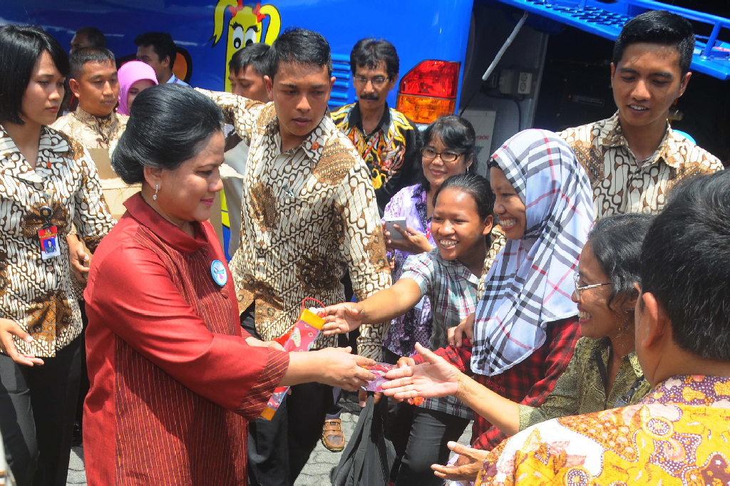 Ibu Negara Iriana Joko Widodo (tengah) memberikan bingkisan kepada warga.