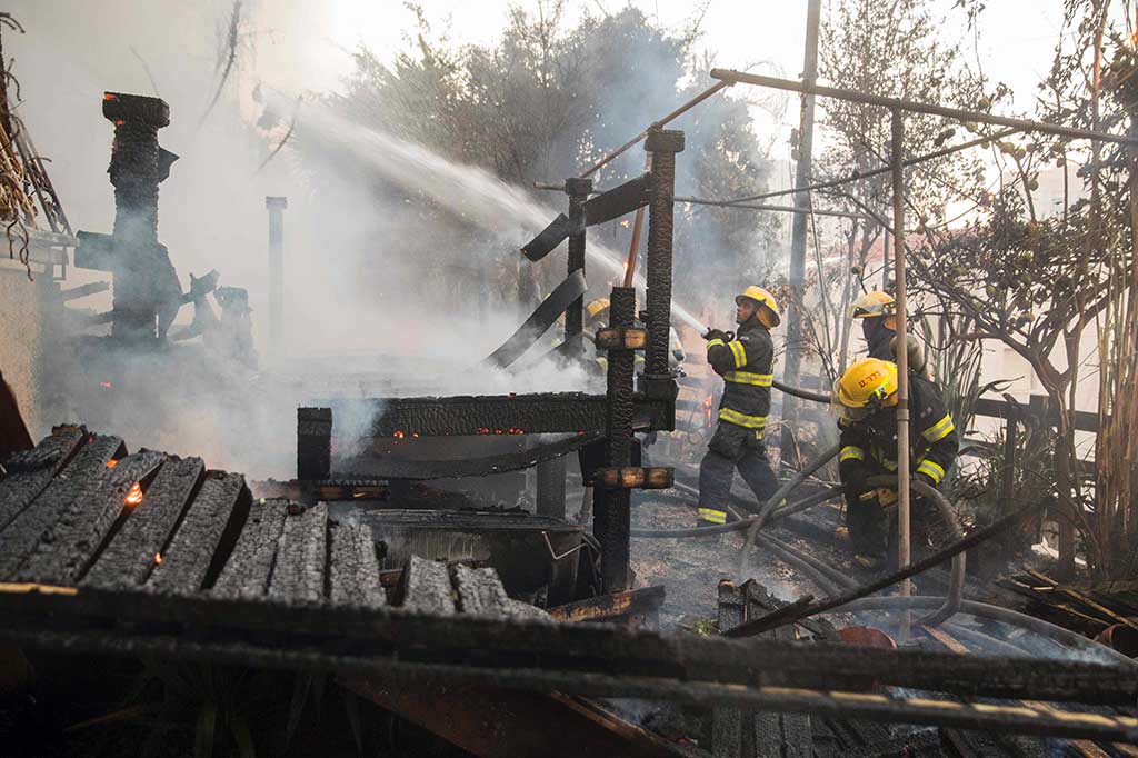 Petugas berusaha memadamkan api yang menghanguskan perumahan warga di Haifa.