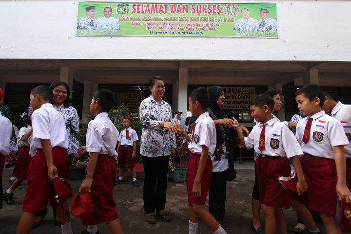 Siswa menyalami guru mereka seusai mengikuti upacara di Sekolah Dasar Negeri 060813 Medan, Sumatera Utara. ANTARA/Septianda Perdana