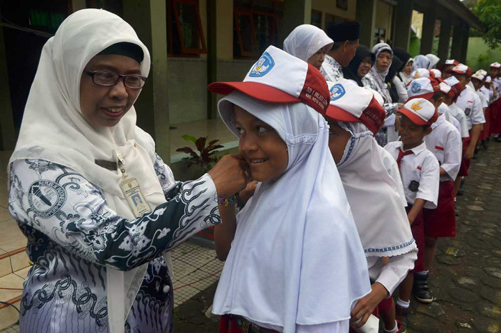 Siswa antre untuk bersalaman dengan guru mereka sambil mengucapkan Selamat Hari Guru di halaman Sekolah Dasar 1 Mlati Lor Kudus, Jawa Tengah. ANTARA/Yusuf Nugroho