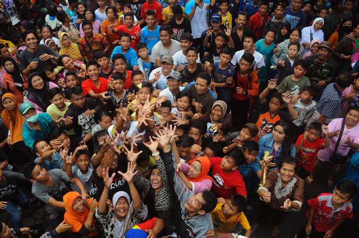 Warga berebut apem keong mas yang disebar.